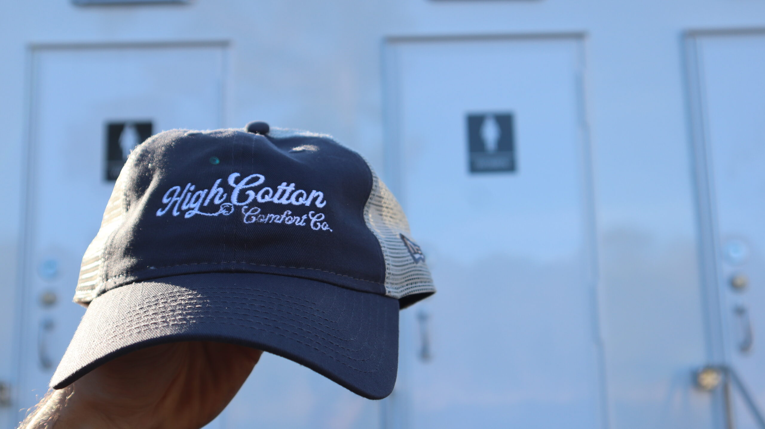 High Cotton Comfort Co news header featuring a branded hat on a truck hood with company logo, representing updates and insights from a Charleston restroom trailer company