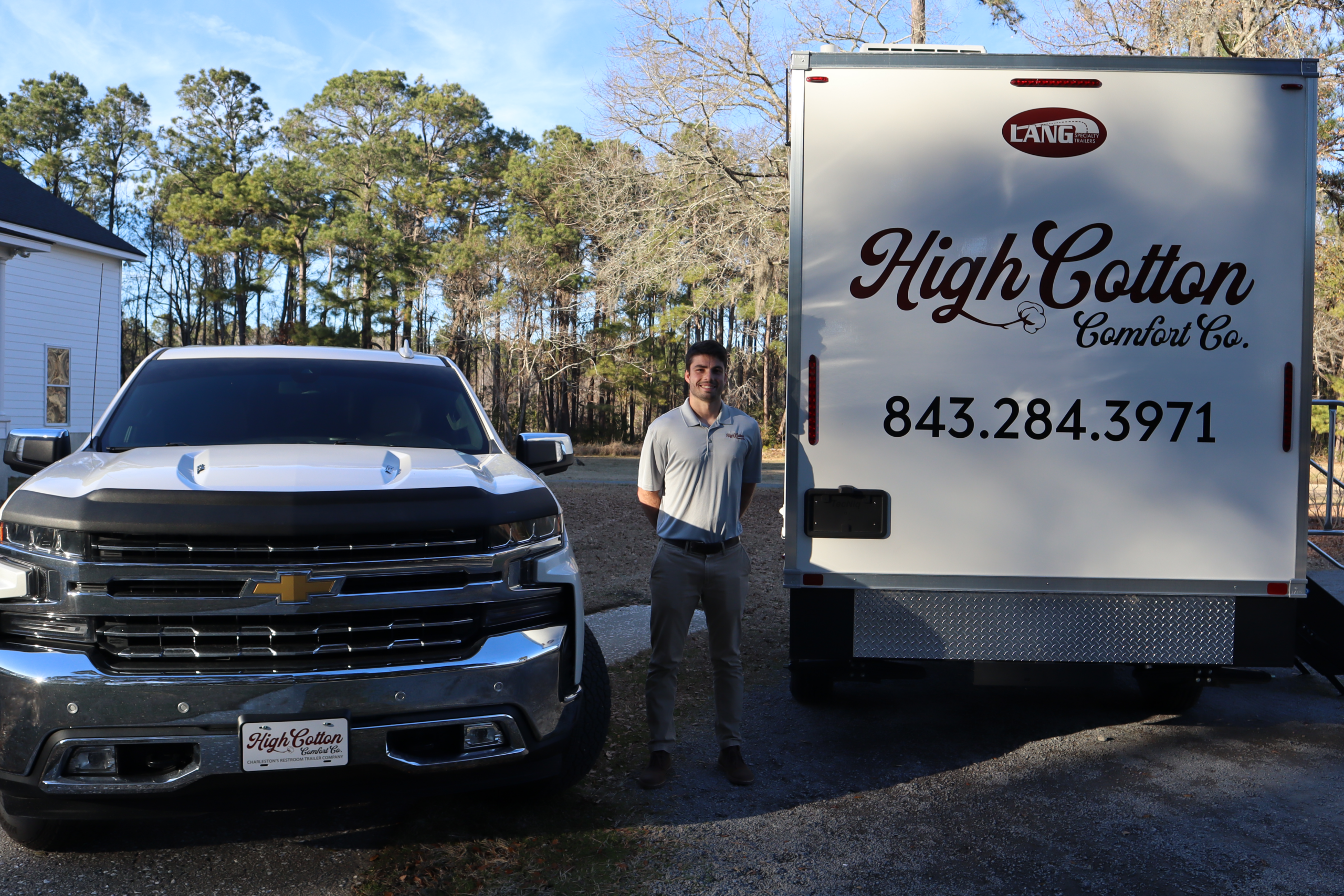High Cotton Comfort Co. team member standing beside a luxury mobile restroom trailer